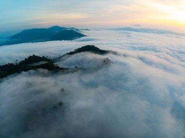 Güneşin dağların tepelerinde doğuşu sisle kaplı, hava manzaralı insansız hava aracı güzel bir gökyüzü çekti. Renkli, aydınlık bir arka plan.