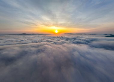 Güneşin dağların tepelerinde doğuşu sisle kaplı, hava manzaralı insansız hava aracı güzel bir gökyüzü çekti. Renkli, aydınlık bir arka plan.