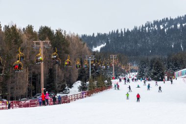 Karakol, Kırgızistan - 21 Ocak 2024: Kayakçılar ve teleferik