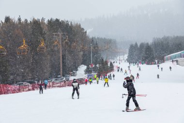 Karakol, Kırgızistan - 21 Ocak 2024: Kayakçılar ve teleferik