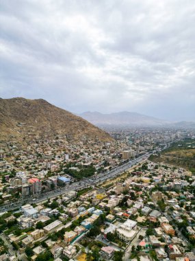 Afganistan 'ın Kabil şehrinin hava görüntüsü. Tepelerde arabaları ve evleri olan şehir yolu.