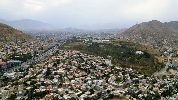 Afganistan 'ın Kabil şehrinin hava görüntüsü. Tepelerde arabaları ve evleri olan şehir yolu.