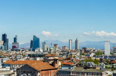 Milan, Italy - March 14, 2023: Panoramic view of Milan showcasing a blend of modern skyscrapers and traditional architecture with distant mountains clipart