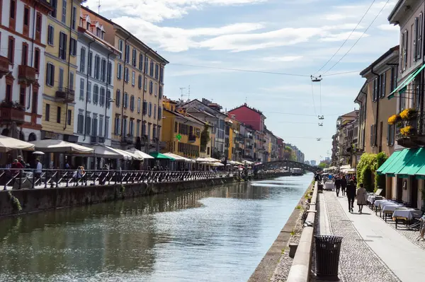 Milan, İtalya - 14 Mart 2023: Milano kanal geçidinde güneşli bir gün, şık renkli binalar ve hareketli sokak kafeleriyle dolu, yoldan geçenleri ve lokantaları davet eden 