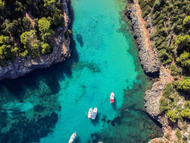 İspanya 'nın Mallorca Adası' ndaki Cala Llombards (Santanyi) plaj koyunda güneşli yaz günlerinde yüzen teknelerin hava görüntüsü