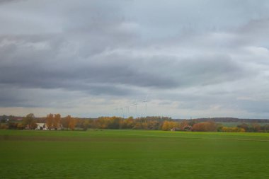 İsveç 'teki tarım arazilerinde dönen rüzgar türbinleri