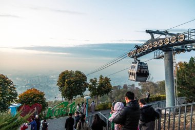 Almaty, Kazakistan - 27 Ekim 2023: Almaty Kazakistan sisli gününde turistler ve teleferikli Kok-tobe tepesi