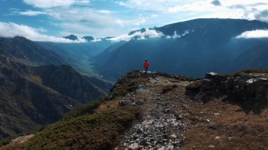 Dağ yamacının sonuna doğru koşan adamın hava görüntüsü.