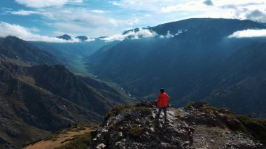 Dağ yamacının sonuna doğru koşan adamın hava görüntüsü.
