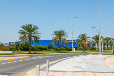 Abu Dhabi, BAE - 24 Nisan 2024: Abu Dabi 'deki IKEA mağazasının dış görünüşü, palmiye ağaçları ile çevrili ve küresel ev mobilyalarının tanınabilir mavi ve sarı markası yer alıyor