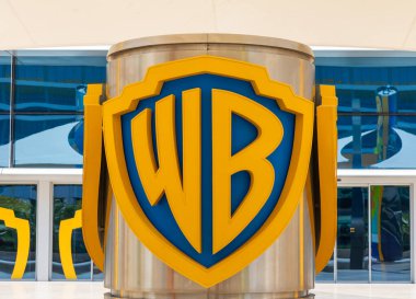 Abu Dhabi, BAE - 24 Nisan 2024: Warner Bros World girişi belirgin bir şekilde gösterilen ikonik logoyu içerir. Canlı sarı ve mavi renkler Abu Dabi 'deki modern mimari tasarıma karşı çıkıyor.