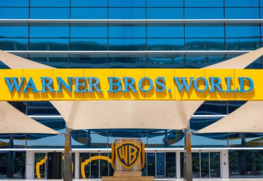 Abu Dhabi, UAE - April 24, 2024: The main entrance of Warner Bros World Abu Dhabi showcases a bright yellow and blue facade with characters like Superman and Scooby-Doo, reflecting the park's lively and welcoming atmosphere clipart