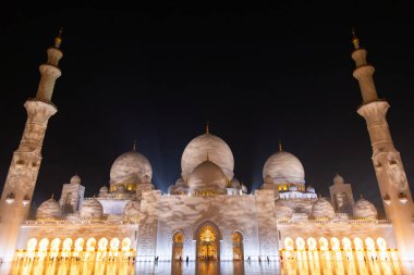 Abu Dabi, BAE - 23 Nisan 2024: Şeyh Zayed Camii ay ışığı altında, mermer cephesini ve parlayan pencerelerini vurguluyor