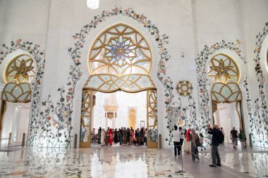 Abu Dhabi, BAE - 23 Nisan 2024 Şeyh Zayed Büyük Camii 'nin iç kesimi ihtişama hayran olan karmaşık çiçek desenleri ve ziyaretçiler sergiliyor.