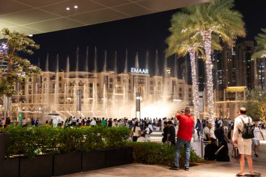 Dubai, Birleşik Arap Emirlikleri - 21 Haziran 2023: Dubai Çeşmesi 'nde geceleyin Burç Halife yakınlarında kalabalık vardı. Dans eden çeşme müzik sırasında su fışkırtıyor.
