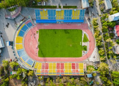 Top down view of stadium with green grass and running track clipart