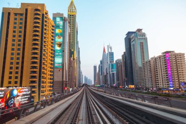 Dubai, Birleşik Arap Emirlikleri - 21 Haziran 2023: Dubai 'deki gökdelenler arasında metro treni