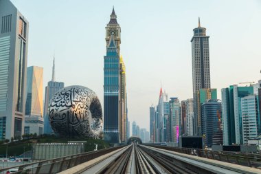 Dubai, Birleşik Arap Emirlikleri - 21 Haziran 2023: Gelecek Müzesi yakınlarındaki Dubai 'de gökdelenler arasında metro yolculuğu