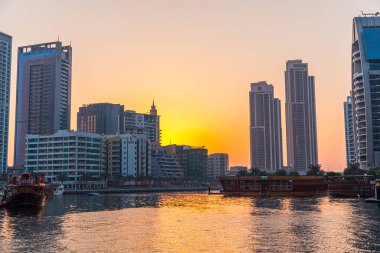 Dubai, Birleşik Arap Emirlikleri - 12 Ekim 2023: Dubai Marina kanalı gün batımında Dubai 'de teknelerle