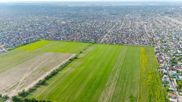 stock image Aerial view of a village near the entrance of Bishkek city, showcasing a mix of residential houses and green fields under a partly cloudy sky