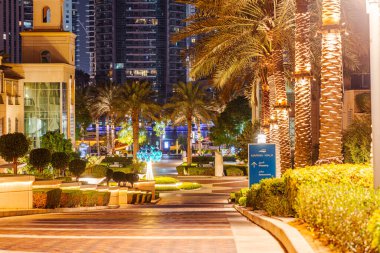 Dubai, Birleşik Arap Emirlikleri - 12 Ekim 2023: Dubai Marina Walk, gece. Küresel kafeler, gıda mağazaları ve restoranlarla benekli yedi kilometre palmiye kaplı sahil yolu..