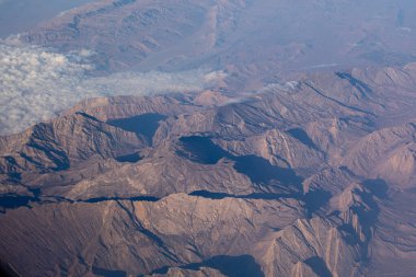 Aerial view of mountain ridges with shadows and light clipart