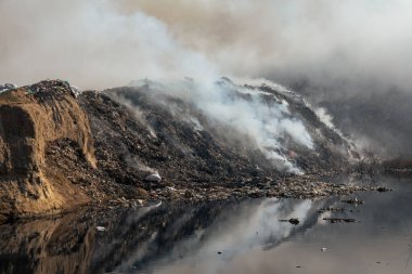 Yanan çöp yığınları ve kirlenmiş zehirli göletlerle doludur.