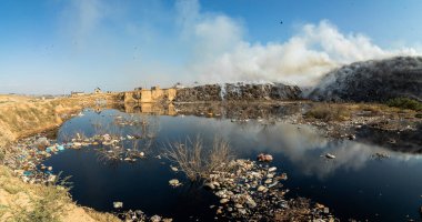Yanan çöp yığınlarının yakınındaki zehirli gölet