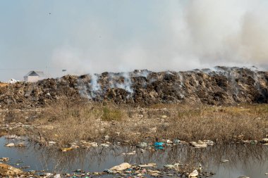 Yanan çöp yığınları ve kirlenmiş zehirli göletlerle doludur.