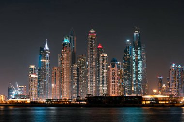 Gece Dubai Marina gökdelenleri Palm Jumeirah adasından görüldü.