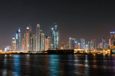 Gece Dubai Marina gökdelenleri Palm Jumeirah adasından görüldü.