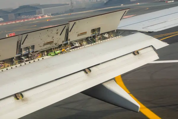 stock image Dubai, UAE - May 14, 2024: Close-up view of mechanical parts on airplane wing during flight