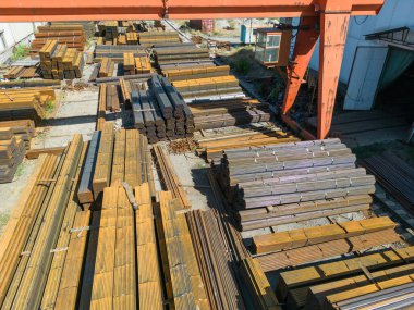 Galvanize demir borular ve paslanmaz çelik dikdörtgen metal çubuklar arka planda gantry vinç ile
