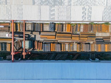 Metal boruları gantry vinçle yükleyen işçilerin havadan aşağı görüntüsü