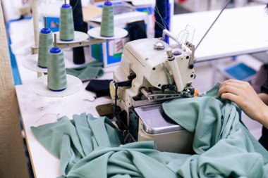 Elektrikli dikiş makinesinde çalışan terzinin kapağı