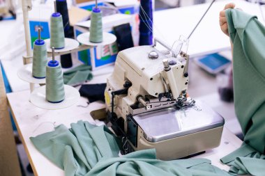 Elektrikli dikiş makinesinde çalışan terzinin kapağı