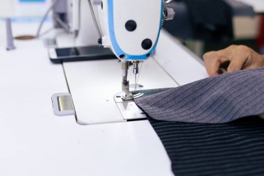 Elektrikli dikiş makinesinde çalışan terzinin kapağı