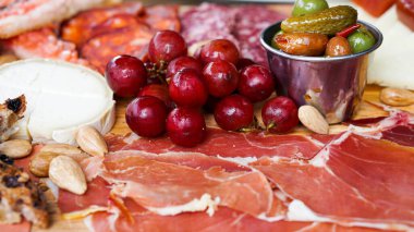 Üzerinde şam fıstığı olan nefis çikolatalı gofretler, siyah bir tepside sunuluyor ve yemek servisi seçeneklerine lüks bir dokunuş ekleniyor.