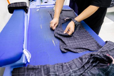 Terzi ütü için kıyafet hazırlıyor.