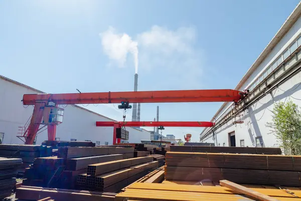 stock image Worker transporting stack of metal pipes with gantry crane in the steel factory