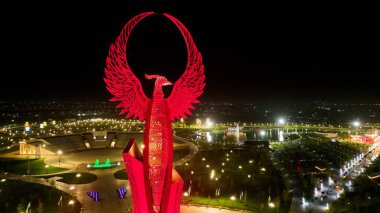 Tashkent, Uzbekistan - December 14, 2022: Aerial view of Huma bird monument in the Yangi Ozbekiston (New Uzbekistan) park in Tashkent city at night. The Huma is a mythical bird of legends clipart