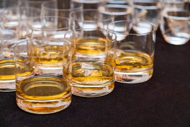 Buzlu çoklu viski bardakları, siyah bir bez üzerine dizilmiş, etkinlikleri veya toplantıları tatmak için ideal.