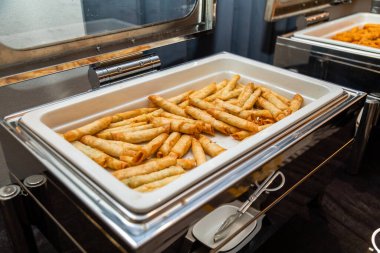 Yeni hazırlanmış börekler metal servis tepsilerinde sunuluyor. Bir etkinlik için yemek servisinin bir parçası.