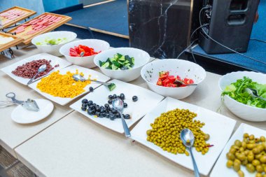 Salatalar, ekmekler, meyveler ve yemek masasında sıralanmış tatlılar da dahil olmak üzere çok çeşitli büfe ürünleri.
