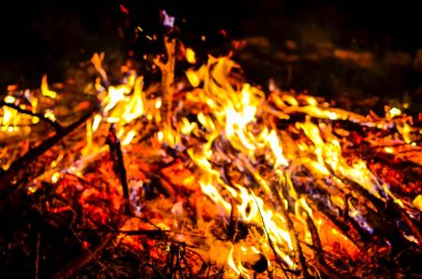 Yanan odunla kamp ateşini söndür.