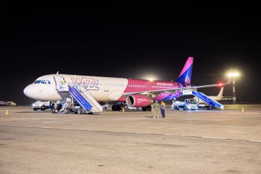 Bishkek, Kırgızistan - 14 Ekim 2023: Manas Havalimanı 'ndaki Wizz Air uçağı yer ekibi ve görünür merdivenlerle