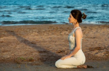 Dışarıda yoga yapan genç güzel bir kadın gün batımında kahraman pozunda gölün kıyısında oturuyor. Uyum, kişisel bakım, rahatlama egzersizleri, sağlıklı yaşam tarzı ve meditasyon konsepti, zen akıl sağlığı