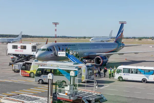 stock image Bishkek, Kyrgyzstan - September 26, 2023: People walking on air stairs to the Russian Aeroflot RA-73178 Airbus A321-211 plane at the Manas International Airport