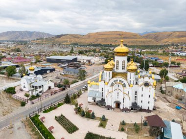 Bişkek, Kırgızistan - 31 Ağustos 2024: Kutsal Havarilere Eşit Ortodoks Kilisesi 'nin havadan görünüşü, altın kubbeleri ve çevresini gösteren Büyük Dük Vladimir