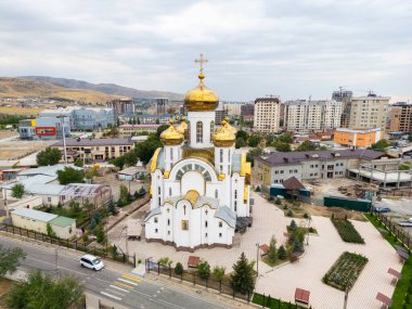 Bişkek, Kırgızistan - 31 Ağustos 2024: Kutsal Havarilere Eşit Ortodoks Kilisesi 'nin havadan görünüşü, altın kubbeleri ve çevresini gösteren Büyük Dük Vladimir